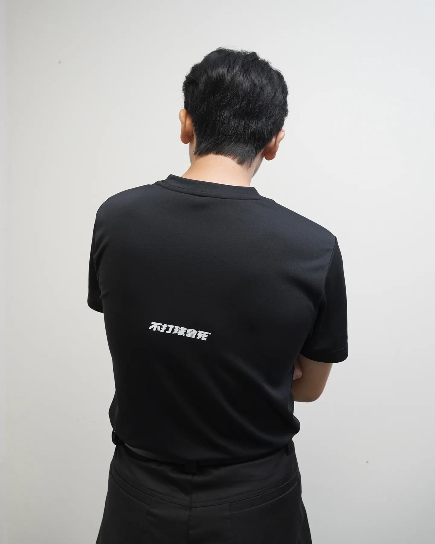 模特穿著黑色基礎素 T 的背面近照